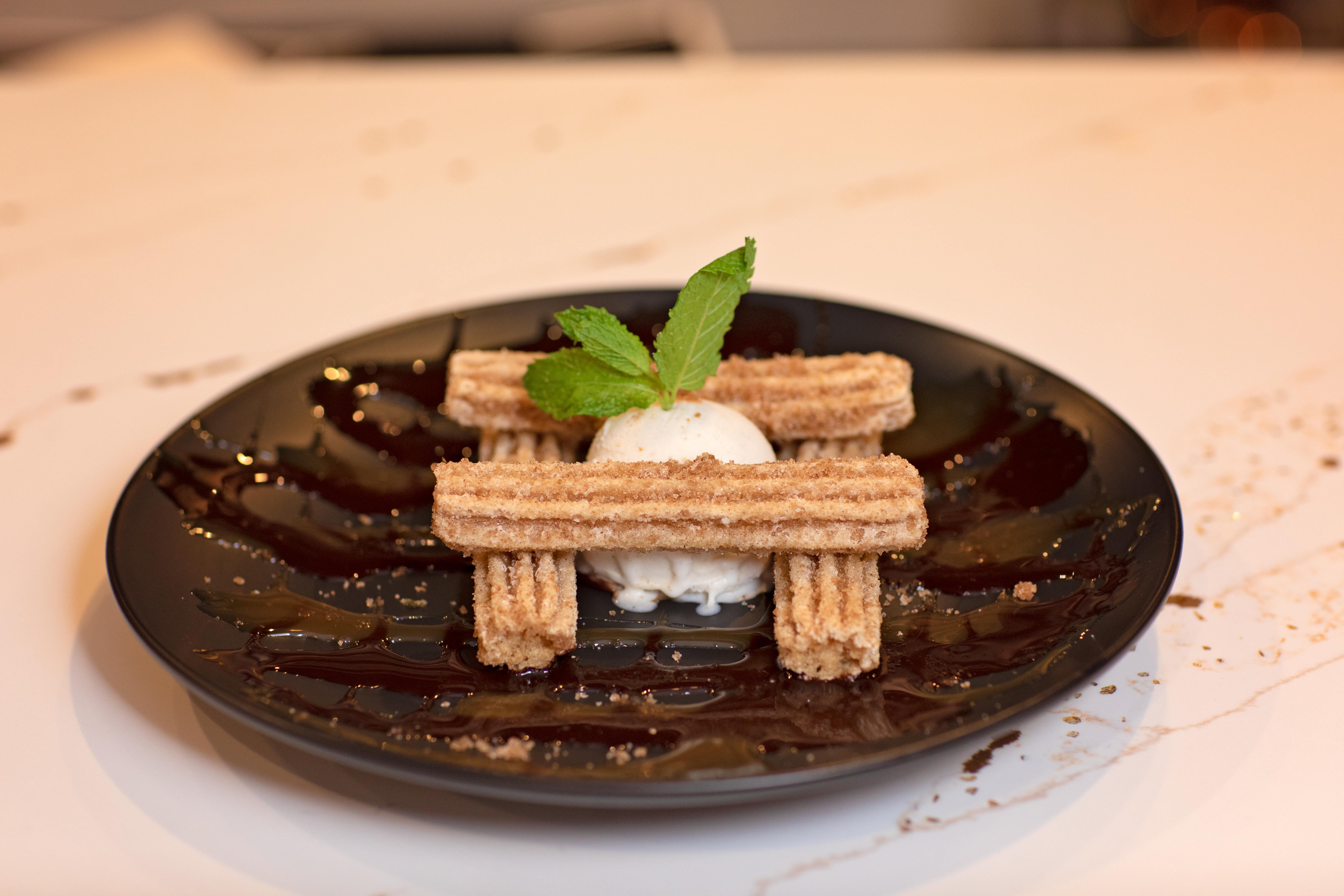 Churros plated on a chocolate-laced slate dish