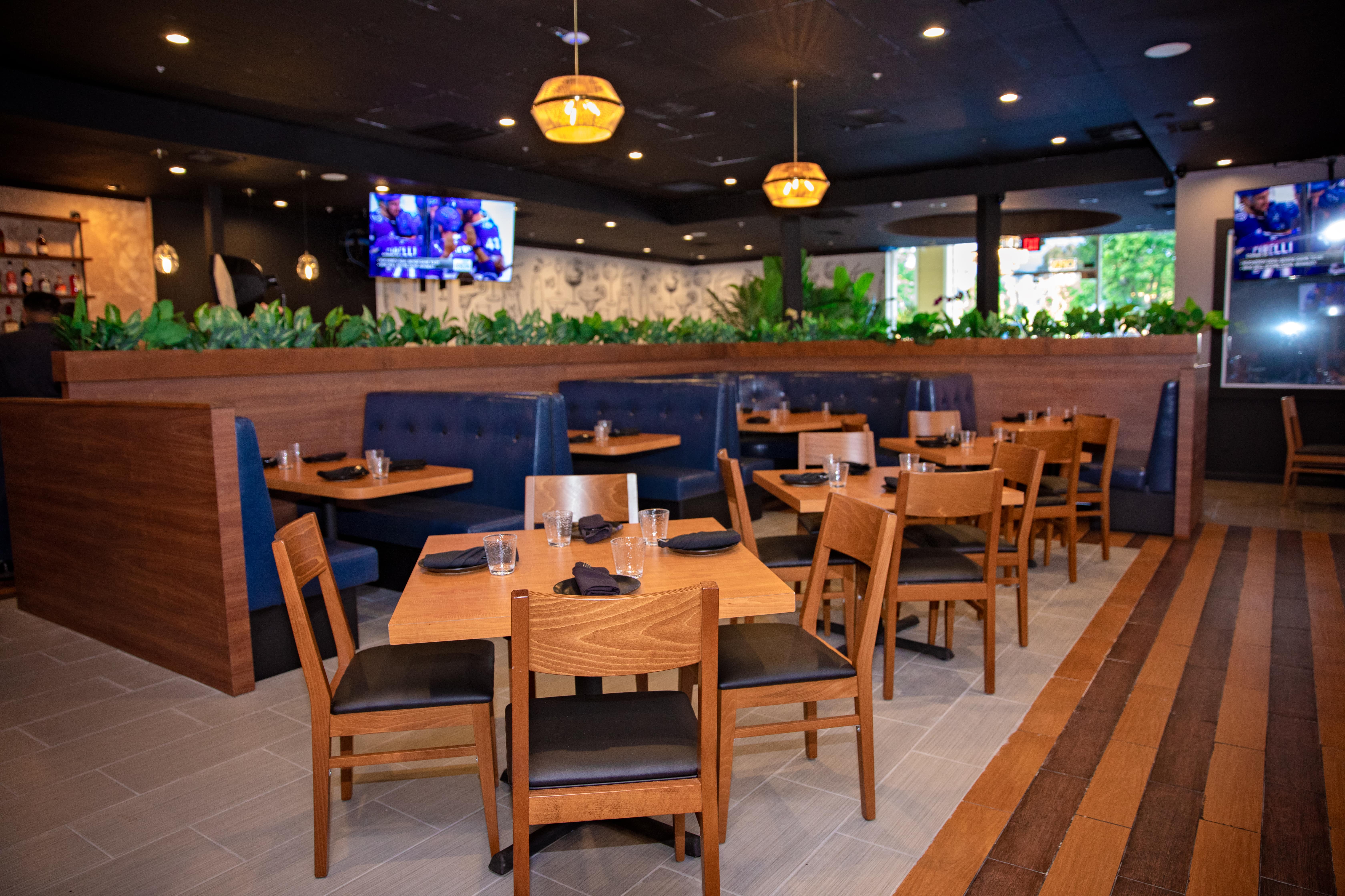 Blue leather booths beneath pendant lights with planter dividers