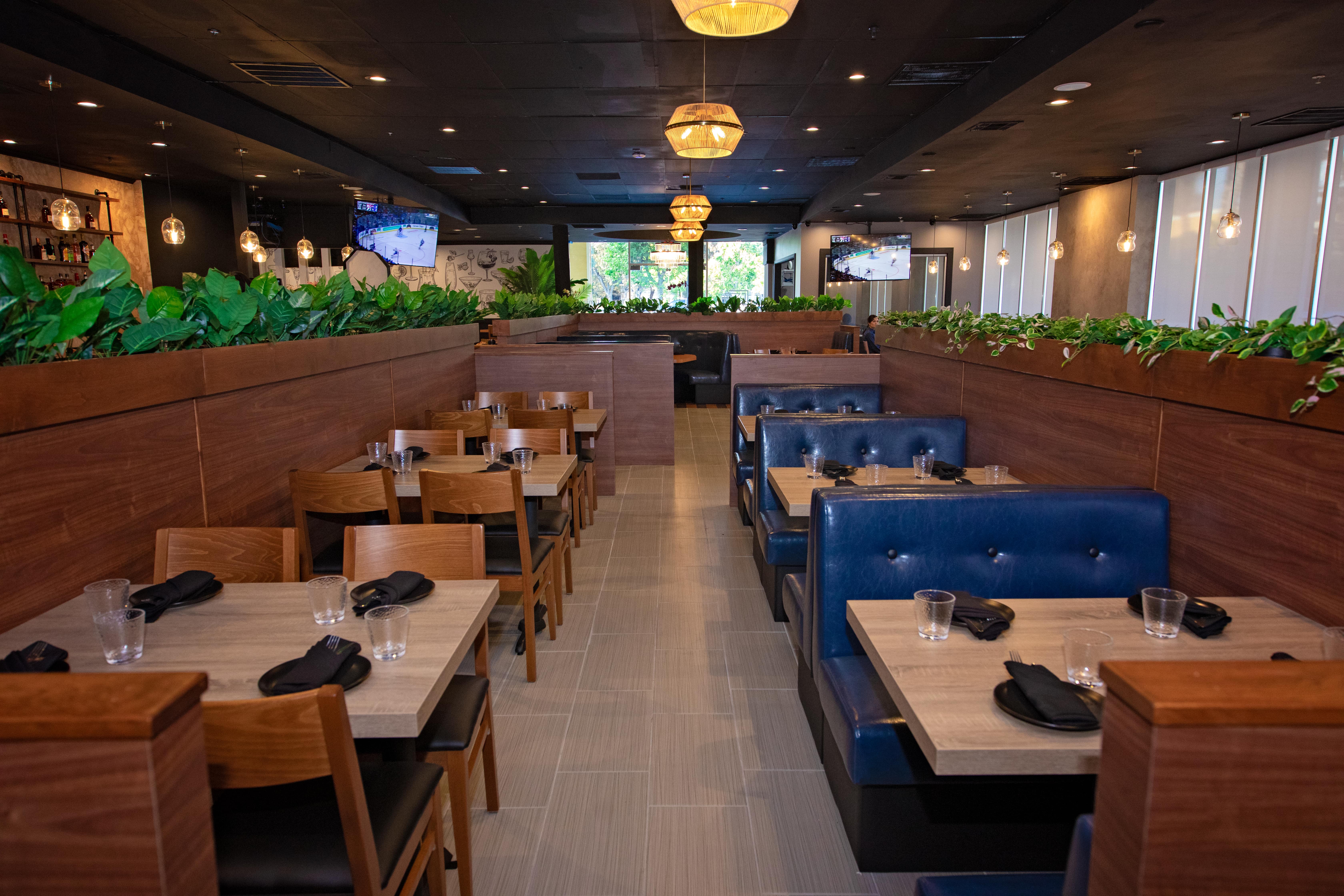 The dining room with booths, wood tables, and warm pendant lighting